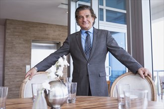 Businessman standing at dining table
