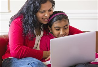 Indian mother and daughter using laptop