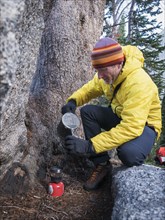 Caucasian hiker pouring coffee outdoors