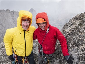 Caucasian climbers smiling on hillside
