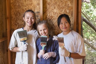 Smiling girls painting house