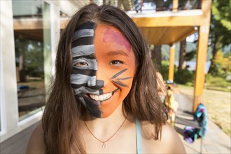 Smiling mixed race girl wearing face paint