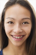 Mixed race girl smiling with braces