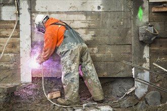 Caucasian worker welding at construction site