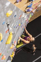Woman belaying climber on rock wall