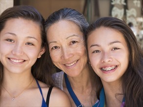 Close up of smiling Asian mother and daughters