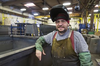 Caucasian welder posing in factory
