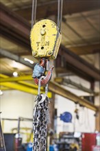 Pulley and chain hanging in factory