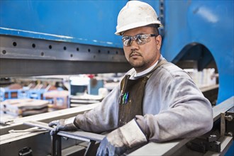 Pacific Islander worker posing in factory