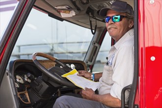 Caucasian semi-truck driver holding paperwork