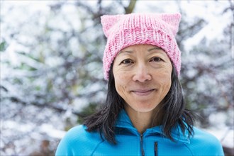 Smiling Japanese woman wearing pink hat with ears
