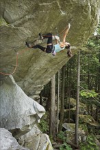 Mixed race girl climbing rock