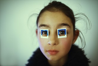 Mixed race girl wearing stickers on eyes