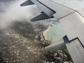 Aerial view of airplane wing flying over Wellington cityscape