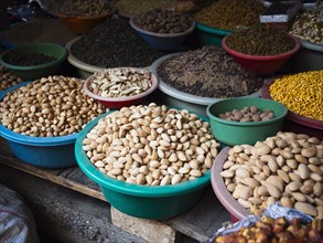 Bowls of dried grains and nuts for sale in market