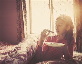 Girl eating breakfast in bed