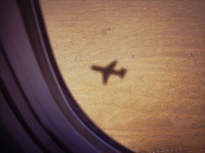 Shadow of airplane on desert ground