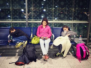 Mother and children relaxing in airport waiting area