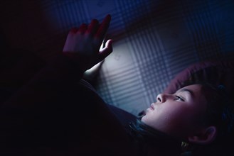Mixed race girl using cell phone at night