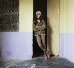 Woman smiling and leaning in doorway