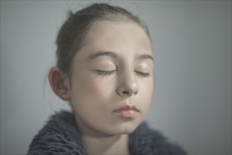 Close up of mixed race girl with eyes closed