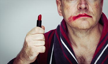 Caucasian man wearing smeared lipstick