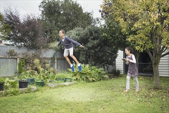 Mixed race children playing with hover toy in backyard
