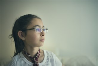 Mixed race girl in eyeglasses looking sideways