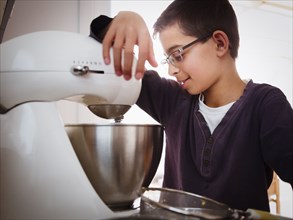 Mixed race boy baking in kitchen
