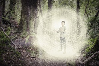 Mixed race boy in digital orb in forest