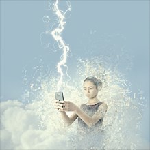 Mixed race girl holding cell phone in lightning