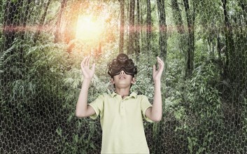 Mixed race boy wearing virtual reality goggles in remote forest