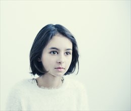 Wide-eyed Mixed Race girl wearing sweater