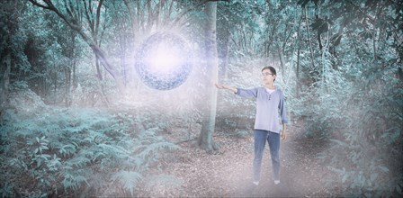 Mixed Race boy with floating sphere in forest