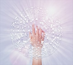 Hand of Mixed Race boy in hovering sphere of pixels