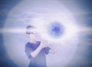 Mixed Race boy using vr goggles watching hovering pixel sphere