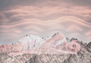 Double exposure of Mixed Race girl laying on mountain landscape