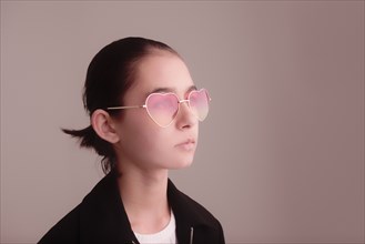 Mixed Race girl wearing heart-shape sunglasses