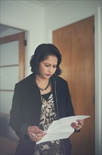 Indian woman reading paperwork