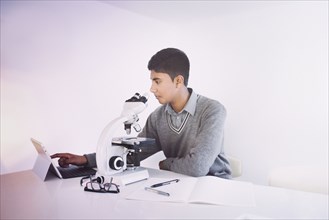 Fiji Indian boy using digital tablet and microscope