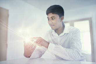 Fiji Indian boy texting on glowing cell phone