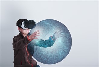 Mixed Race boy wearing VR goggles holding sphere