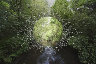 Nature sphere hovering over river in forest