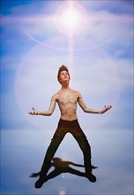 Shirtless man looking at glowing sky