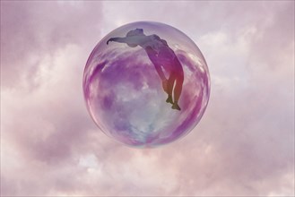 Woman floating in sphere in clouds