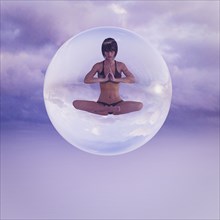 Woman floating in sphere meditating