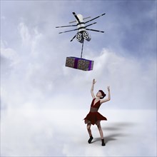 Girl reaching for gift delivered by drone