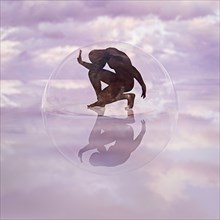Naked man crouching in transparent sphere