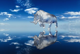 Reflection of glass rhinoceros in blue sky