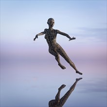 Reflection of futuristic woman dancing in sky